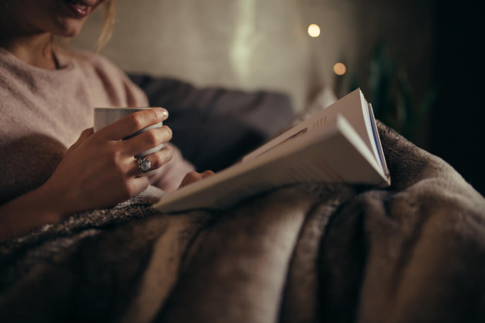 Woman reading book at night