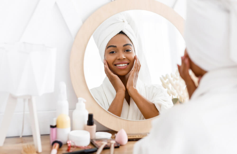 Woman looking in mirror touching face