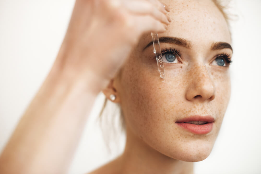 Woman applying face serum