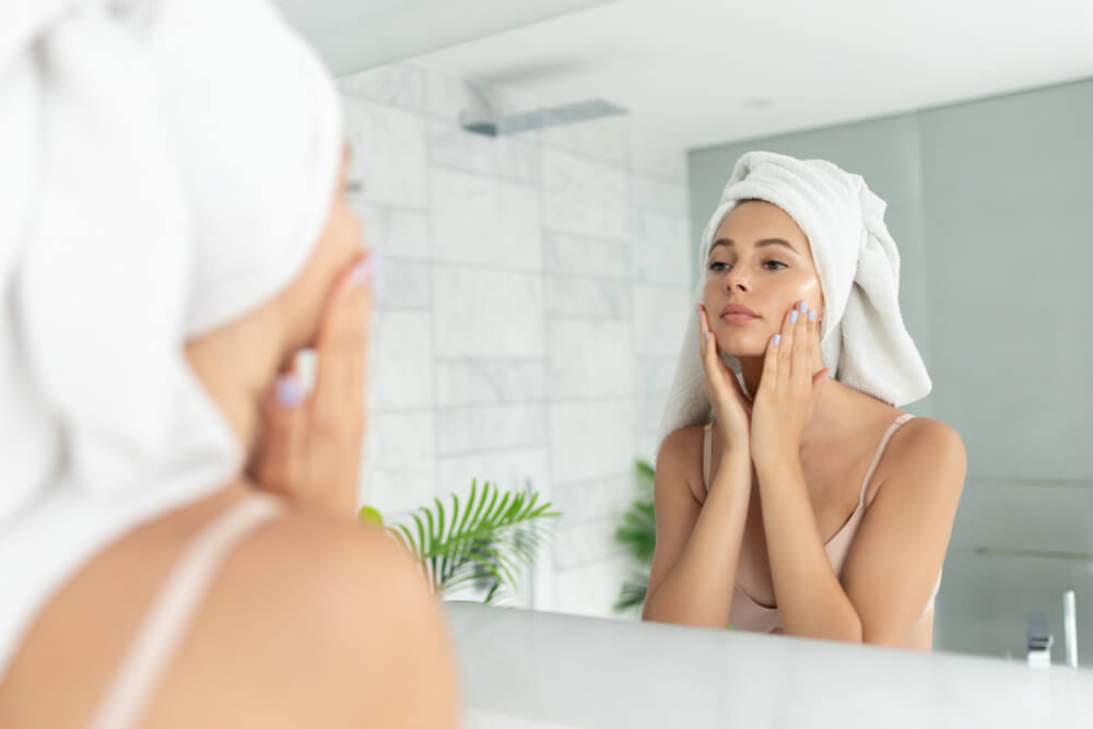 Woman looking at skin in mirror