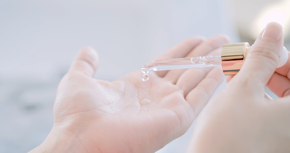 Woman applying serum to hand