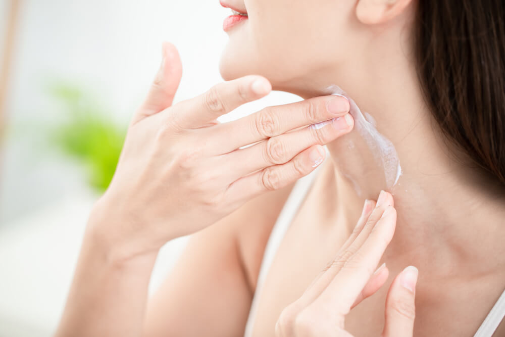 Woman applying neck cream