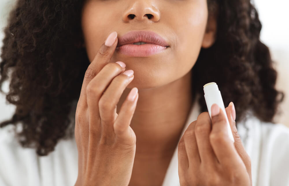 Woman using lip balm for lip care