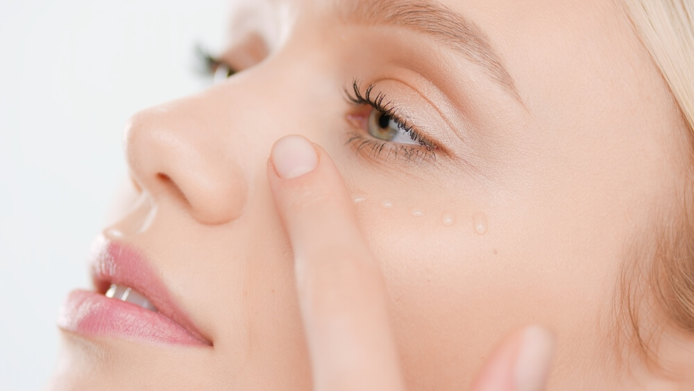 Woman applying eye serum