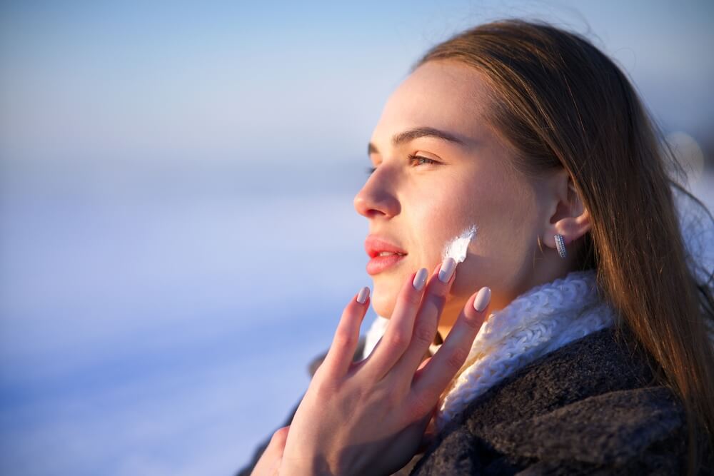 woman applying moisturizer