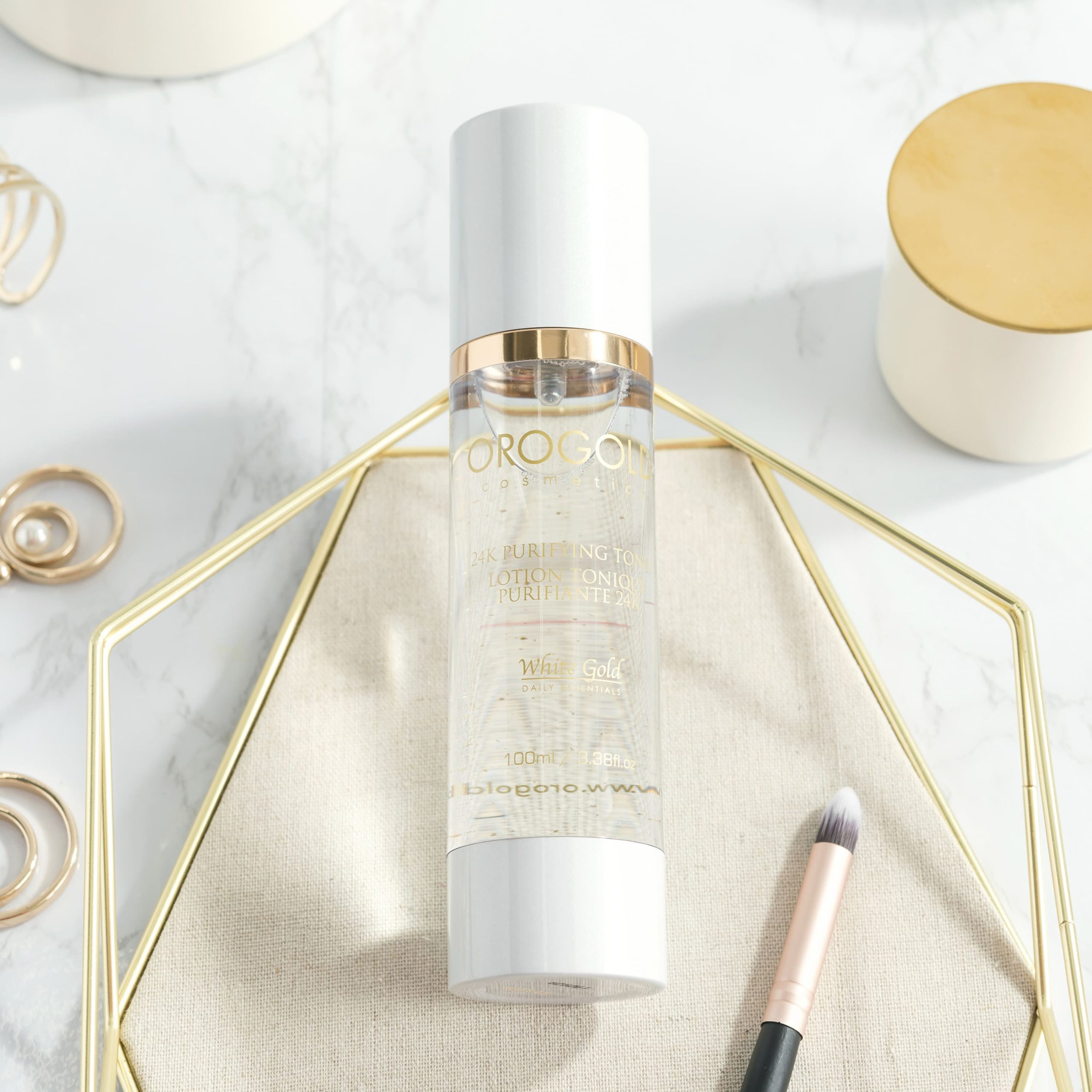 OROGOLD Purifying Toner next to makeup and accessories