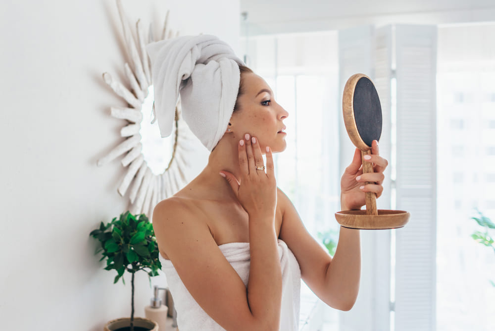 Woman looking at skin microbiome diversity in the mirror
